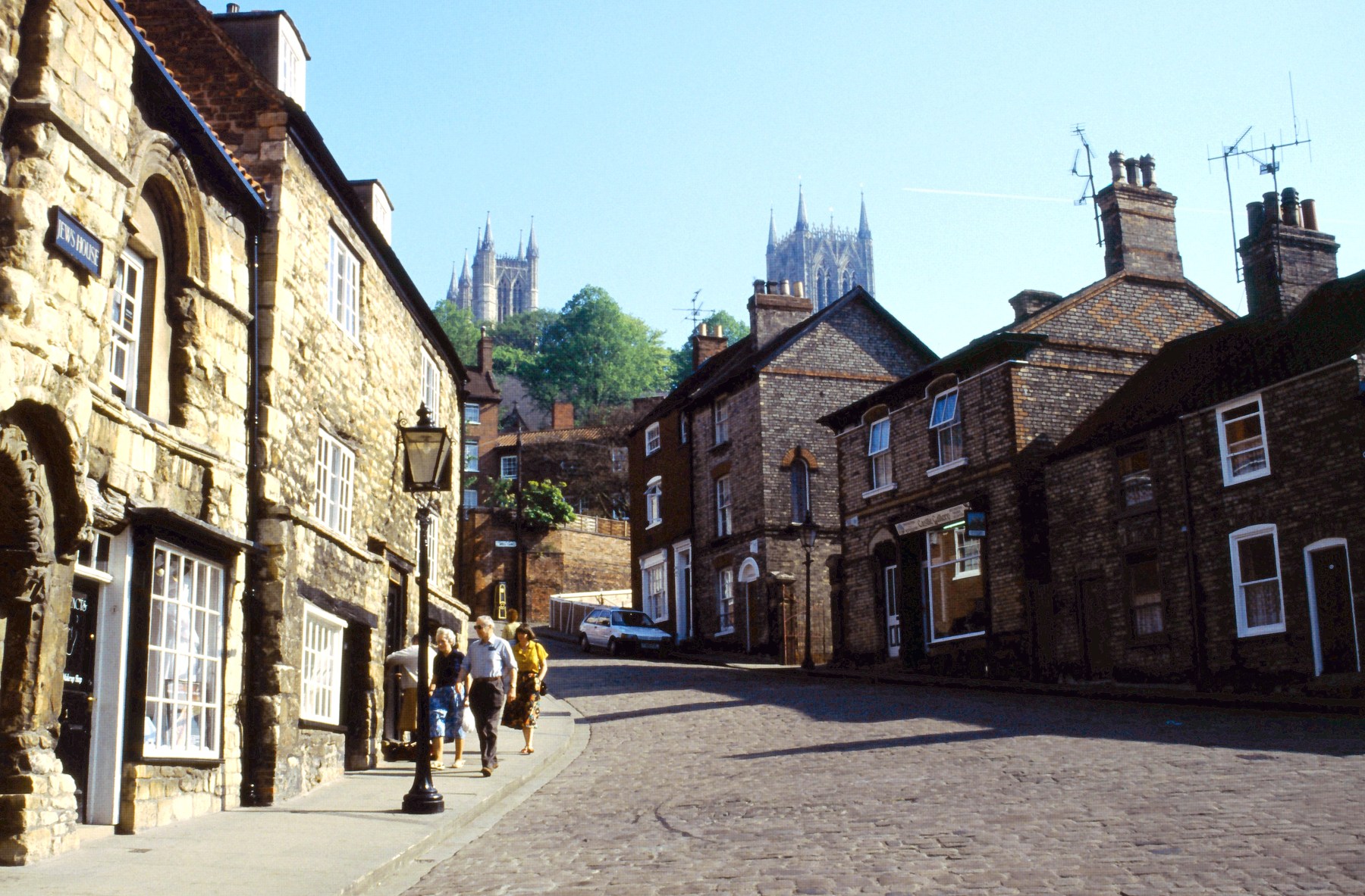 Steep Hill in Lincoln, with historic buildings and cathedral towers in the distance